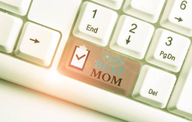 En İyi Anne 'yi gösteren bir not yazıyorum. Annen için iş fotoğrafı gösterme memnuniyeti duyguları iltifat Beyaz bilgisayar klavyesi beyaz arka planda not kağıdı ile.