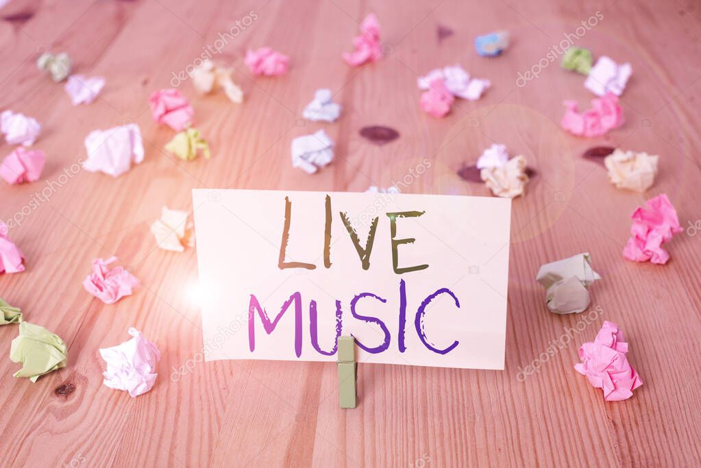 Conceptual hand writing showing Live Music. Business photo text perforanalysisce given by one or more singers or instrumentalists Colored crumpled papers wooden floor background clothespin.