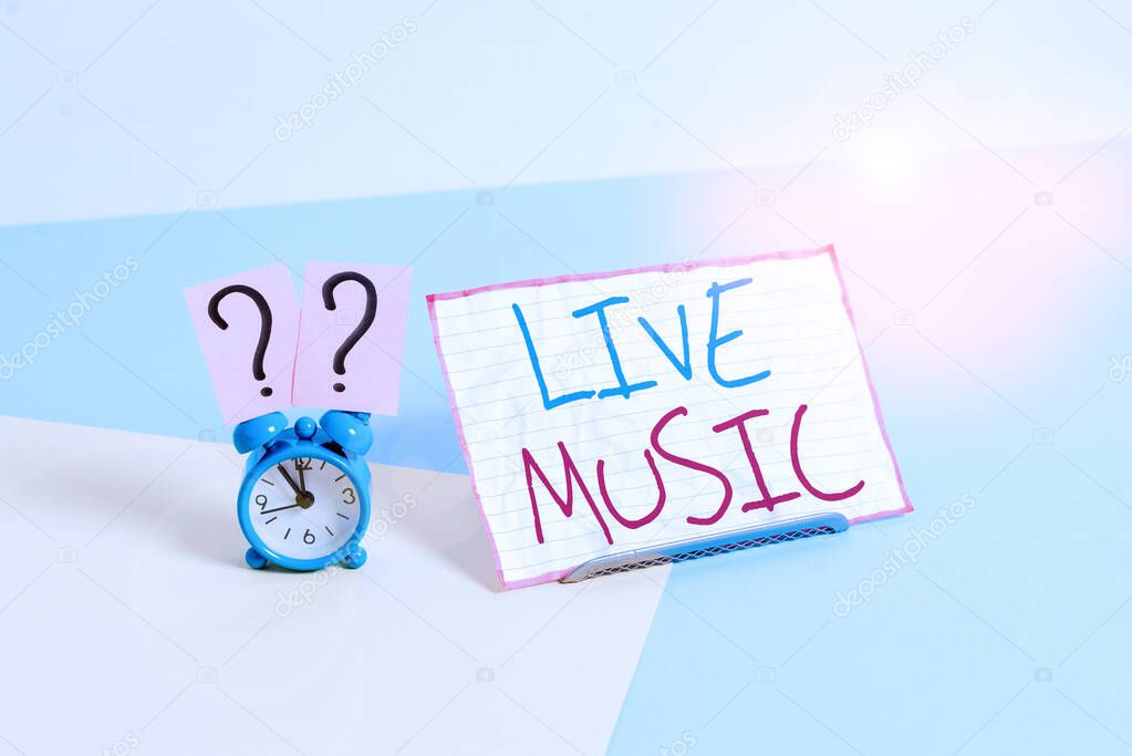 Handwriting text Live Music. Concept meaning perforanalysisce given by one or more singers or instrumentalists Mini size alarm clock beside a Paper sheet placed tilted on pastel backdrop.