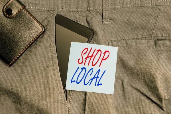 Conceptual hand writing showing Shop Local. Business photo text a preference to buy locally produced goods and services Smartphone device inside trousers front pocket with wallet.