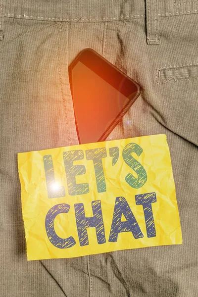 Writing note showing Let S Is Chat. Business photo showcasing inviting the demonstrating to have informal conversation with you Smartphone device inside trousers front pocket note paper.