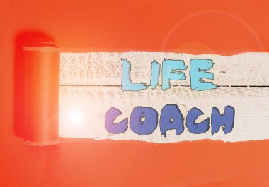 Word writing text Life Coach. Business concept for someone who helps identify your goals and plan to achieve them Cardboard which is torn in the middle placed above a wooden classic table. clipart