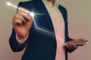 Erkek insan en son gelişmiş cihazları kullanarak sunum yapıyor. Adam, akıllı aletlerin nasıl çalıştığını gösteren resmi bir takım elbise giyiyor. Modern hayatın fotoğrafı..