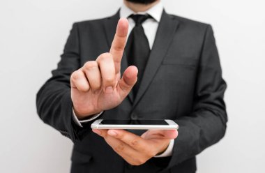 Sakallı bir erkek resmi iş kıyafetleri giyer yüksek teknoloji akıllı telefon cihazı taşır. İş elbisesi giymiş bir adam ve kravatlı küçük cep telefonlu bir adam tek elini kullanıyor.