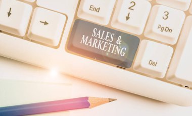 Satış ve Pazarlama 'yı gösteren kavramsal el yazısı. Beyaz arkaplanının üzerinde not kağıdı ile birlikte mal veya hizmetlerin dağılımının tanıtımını gösteren iş fotoğrafı.