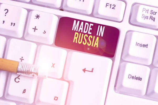 显示俄罗斯制造的文字标志。概念照片俄罗斯白色键盘中的一种产品或东西，在空白的背景键复制空间上方附有空白的便条。. — 图库照片