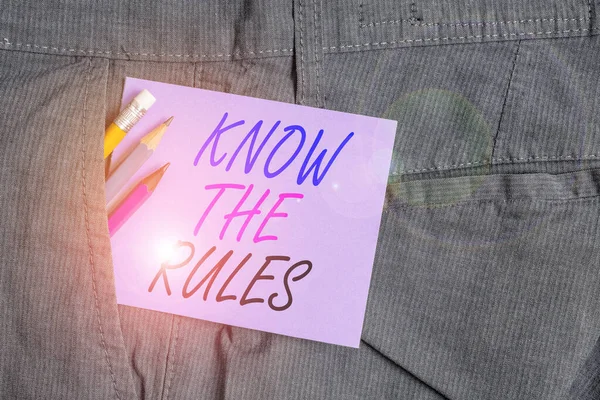 Writing note showing Know The Rules. Business photo showcasing Learn the accepted principle or instructions to follow Writing equipment and purple note paper inside pocket of trousers. — Stock Photo, Image