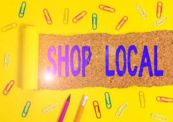 Conceptual hand writing showing Shop Local. Business photo text a preference to buy locally produced goods and services Stationary and torn cardboard on a wooden classic table backdrop.