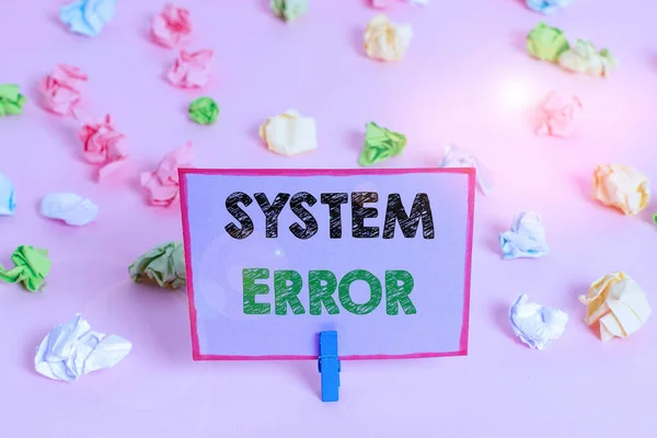 Writing note showing System Error. Business photo showcasing instruction that is not recognized by an operating system Colored crumpled papers empty reminder pink floor background clothespin.