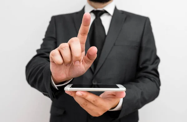 Man människa med skägg bära formella arbetskläder hålla högteknologiska smartphone-enhet. Man klädd i arbetskläder plus slips håller liten mobil hi tech telefon med en hand — Stockfoto