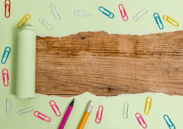 Carton déchiré avec trombone placé au-dessus d'une table classique en bois. Papier épais déchiré et fixe sur une toile de fond en bois texturé. Manière artistique d'arranger la photographie de pose à plat — Photo