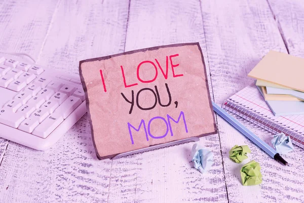 Conceptual hand writing showing I Love You Mom. Business photo showcasing Loving message emotional feelings affection warm declaration Notepaper on wire in between computer keyboard and sheets. — ストック写真