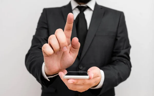 Hombre humano con barba usar ropa de trabajo formal celebrar dispositivo de teléfono inteligente de alta tecnología. Hombre vestido con traje de trabajo más corbata sosteniendo un pequeño teléfono móvil de alta tecnología con una mano — Foto de Stock