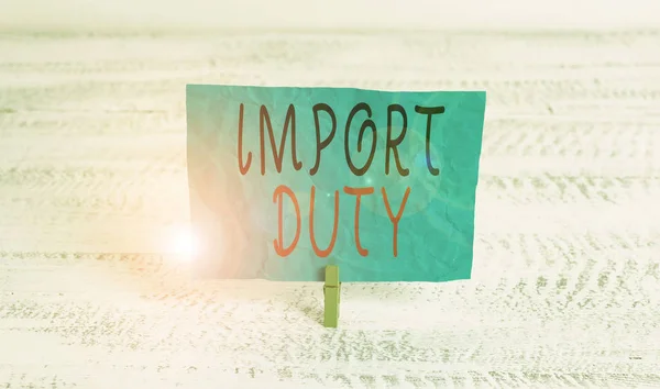 Slovo psaní textu Import Duty. Obchodní koncept pro daň uvalenou vládou na zboží z jiných zemí Zelené prádlo kolík bílé dřevo pozadí barevný papír upomínka kancelářské dodávky. — Stock fotografie