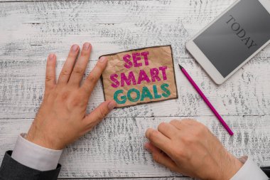 Akıllı Hedefleri Gösteren Metin İşareti. Kavramsal fotoğraf erişilebilir hedefler belirlemek iyi iş planları yapmak Yazma ekipmanları ve modern akıllı telefon aygıtı yanında not kağıdı tutun.