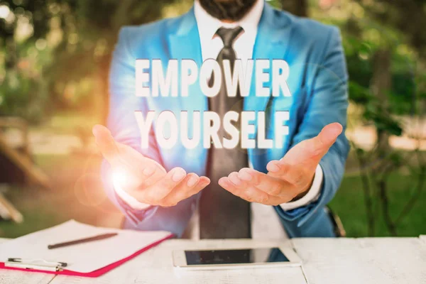 Textschild, das zeigt, wie man sich selbst ermächtigt. konzeptionelles Foto, das einem die Macht gibt, sein eigenes Schicksal selbst in die Hand zu nehmen, Mann mit offenen Händen vor dem Tisch. Handy und Notizen auf dem Tisch. — Stockfoto