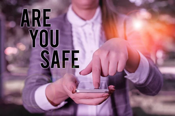 Szövegírás: Biztonságban vagy? Üzleti koncepció veszélytől mentes Nem számít semmilyen káros fizikai sérülésre A szürke lakosztályokban lévő nő hordozza a mobiltelefont. — Stock Fotó