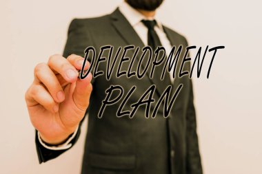 Writing note showing Development Plan. Business photo showcasing the planning of the development of an area of land Male human with beard wear formal working suit clothes hand.
