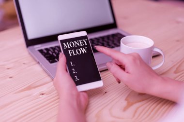 Para akışını gösteren kavramsal el yazısı. İş fotoğrafı, bilgisayarlı akıllı telefon ve ofis teknolojisi olan bir iş kadını, artan veya azalan para miktarına mesaj atar..