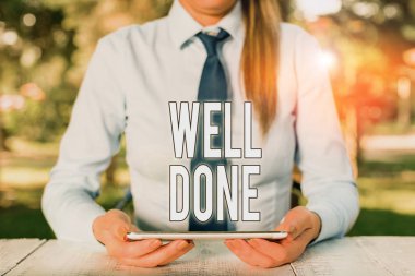 Bravo 'yu gösteren bir not yazıyorum. İş fotoğrafı gösterimi, görevini ya da işini mükemmel bir şekilde yaptığını gösteriyor. Masanın başında oturan ve elinde cep telefonu tutan bir kadın işadamı..