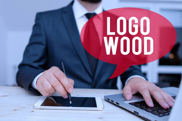 Word writing text Logo Wood. Business concept for Recognizable design or symbol of a company inscribed on wood Male human wear formal clothes present presentation use hi tech smartphone.