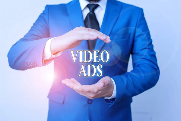 Conceptual hand writing showing Video Ads. Business photo showcasing Engage audience in the form of video content advertising Man in front of table. Mobile phone and notes on the table. — Stock Photo, Image