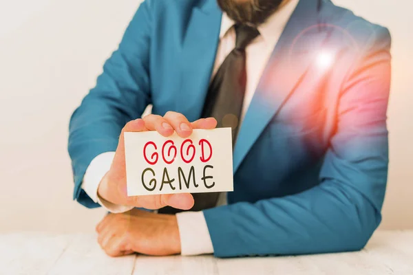 Szóírás szöveg Good Game. Üzleti koncepció a többjátékos játékokban gyakran használt kifejezéshez a mérkőzés végén Az ember üres papírt tart maga előtt másolási hellyel. — Stock Fotó