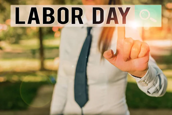 Writing note showing Labor Day. Business photo showcasing an annual holiday to celebrate the achievements of workers Handsome business girl pointing with finger into empty space.