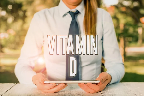 Nota de Escritura mostrando Vitamina D. Foto comercial mostrando Nutriente responsable de aumentar la absorción intestinal Persona de negocios sentada junto a la mesa y sosteniendo el teléfono móvil . —  Fotos de Stock