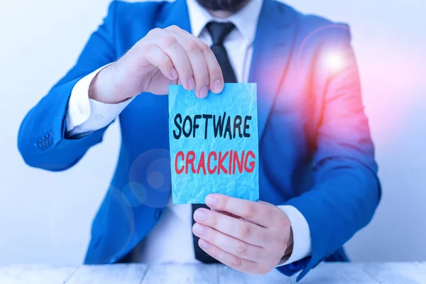 Conceptual hand writing showing Software Cracking. Business photo showcasing modification of software to remove or disable features Man holds empty paper with copy space in front of him Space.