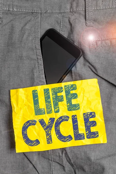 Γράμμα που δείχνει τον Κύκλο Ζωής. Επαγγελματική φωτογραφία που δείχνει τη σειρά των αλλαγών στη ζωή ενός οργανισμού και των ζώων Smartphone συσκευή στο εσωτερικό παντελόνι μπροστά χαρτί σημειώσεων τσέπη. — Φωτογραφία Αρχείου