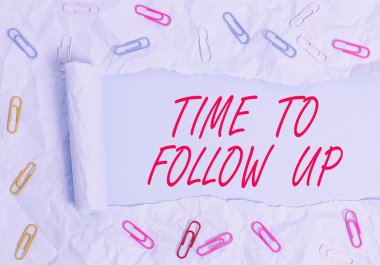 Text sign showing Time To Follow Up. Conceptual photo Enquiry of the previous task or information Continuation Paper clip and torn cardboard placed above a plain pastel table backdrop.