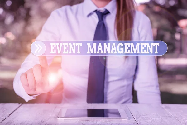 Word writing text Event Management. Business concept for job of planning and analysisaging large events or conferences Female business person sitting by table and holding mobile phone.