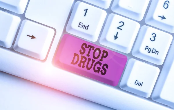 Texto escrito por palavra Stop Drugs. Conceito de negócio para acabar com a dependência de substâncias como heroína ou cocaína Teclado de PC branco com papel de nota vazio acima do espaço de cópia da chave de fundo branco . — Fotografia de Stock