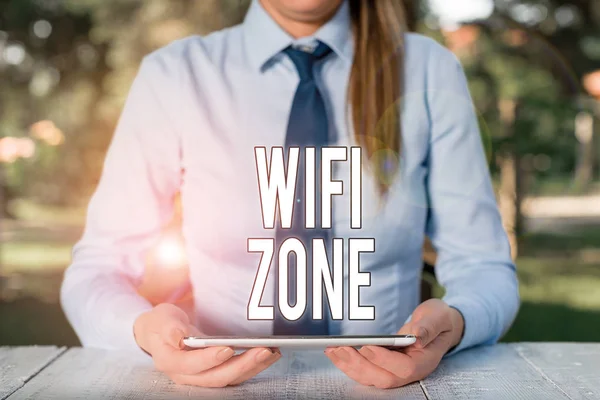 写字条显示威菲区。商业照片展示会提供无线高速互联网和网络连接女商人坐在桌旁拿着手机. — 图库照片