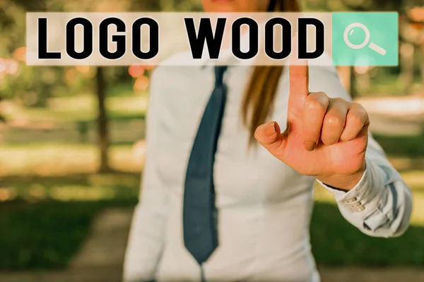 Nota de escrita mostrando Logo Wood. Foto de negócios mostrando Design reconhecível ou símbolo de uma empresa inscrita em madeira Menina de negócios bonito apontando com o dedo para o espaço vazio . — Fotografia de Stock