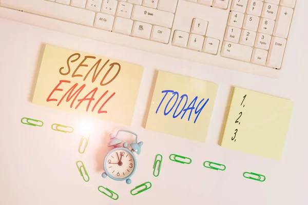 Handwriting text Send Email. Concept meaning the system for using computers to send messages over the internet Empty orange square papers and clock by the pc keyboard with copy space.