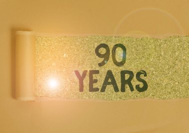 Mesaj işareti 90 yılı gösteriyor. Kavramsal fotoğraf hatırlamak ya da onurlandırmak için özel bir gün 90 yıllık bir varoluş için karton ortadan yırtılmış ahşap klasik bir masanın üzerine yerleştirilmiş.