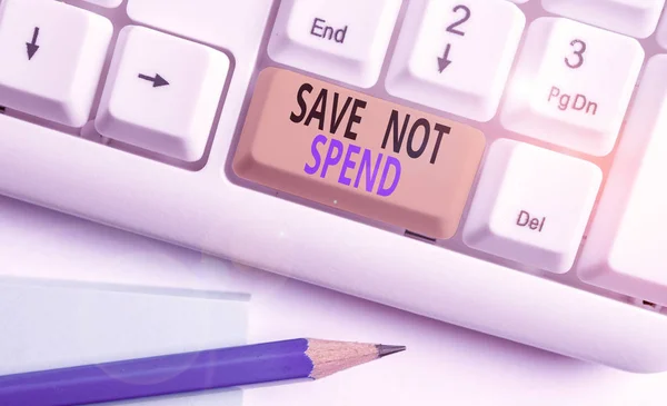 Texto escrito por palavras Save Not Spend. Conceito de negócio para manter o dinheiro para investimento em vez de comprar não necessário Teclado de PC branco com papel de nota vazio acima do espaço de cópia de chave de fundo branco . — Fotografia de Stock