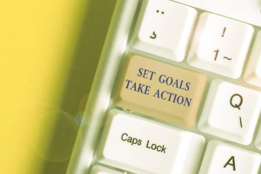 Writing note showing Set Goals Take Action. Business photo showcasing Act on a specific and clearly laid out plans White pc keyboard with note paper above the white background.
