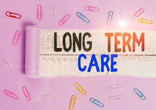 Handwriting text Long Term Care. Concept meaning Adult medical nursing Healthcare Elderly Retirement housing Paper clip and torn cardboard placed above a wooden classic table backdrop.