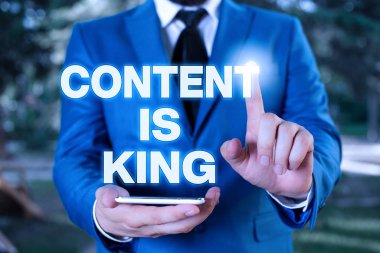 İçeriğin Kral olduğunu gösteren kavramsal el yazısı. İş fotoğrafçılığı içeriği, bugünün pazarlama stratejilerinin kalbidir. İş adamı tam önünde işaret eder..