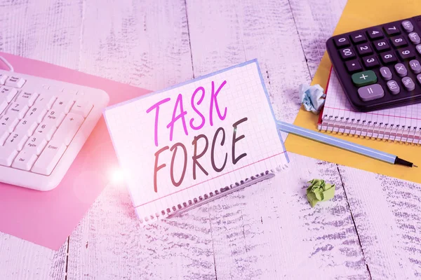 Text sign showing Task Force. Conceptual photo a group of showing who are brought together to do a particular job Notepaper stand on buffer wire in between computer keyboard and math sheets.