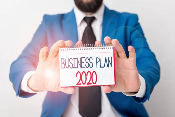 Texto para escribir palabras Plan de negocios 2020 Concepto de negocio para desafiar las ideas y metas de negocio para el año nuevo El hombre sostiene papel vacío con espacio para copiar delante de él Copiar espacio . —  Fotos de Stock
