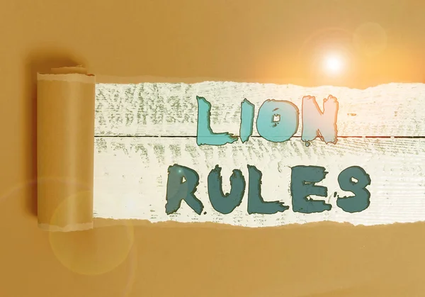 Word writing text Lion Rules. Business concept for epitome of strength power and masculinity Master of own domain Cardboard which is torn in the middle placed above a wooden classic table.