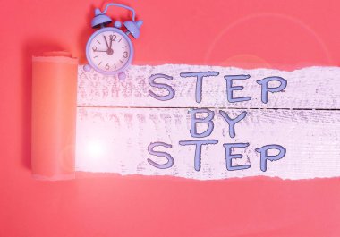 Adım adım yazan el yazısı. Kavram, başarı için Yavaş ilerleme yolu. Yönlendirme geliştirme. Büyüme Alarm saati ve yırtık karton..