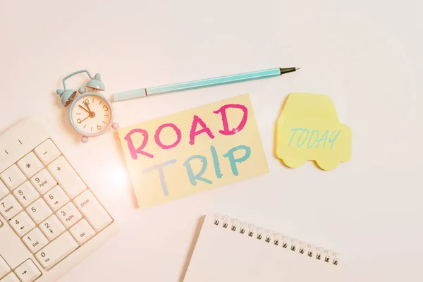 Word writing text Road Trip. Business concept for long distance journey on the road traveled by automobile Copy space on empty note paper with clock and pencil on the table.