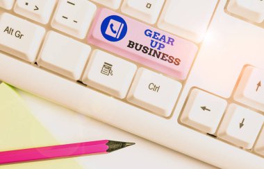 Gear Up Business 'ı gösteren kavramsal el yazısı. Fikir ihtiyaçlarını değerlendirmek ve beyaz arkaplan üzerinde not kağıdı olan beyaz pc klavye planı yaratmak için iş fotoğrafı görüntüleme aracı.