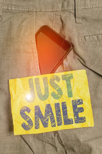 Píšu dopis ukazující Just Smile. Obchodní fotografie showcasing předpokládat výraz obličeje naznačující potěšení nebo pobavení Smartphone zařízení uvnitř kalhot přední kapsa poznámkový papír. — Stock fotografie