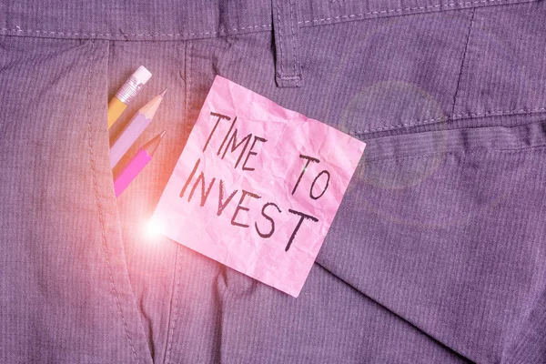 Text sign showing Time To Invest. Conceptual photo Creation of capital capable of producing other goods Writing equipment and pink note paper inside pocket of man work trousers.